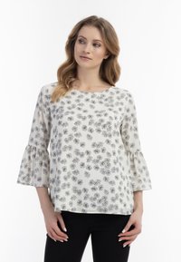 Hvid bluse med sort blomsterprint, rund halsudskæring og trekvart lange klokkeærmer. Glat stof med en afslappet pasform.