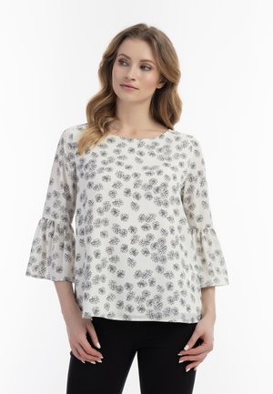 Hvid bluse med sort blomsterprint, rund halsudskæring og trekvart lange klokkeærmer. Glat stof med en afslappet pasform.