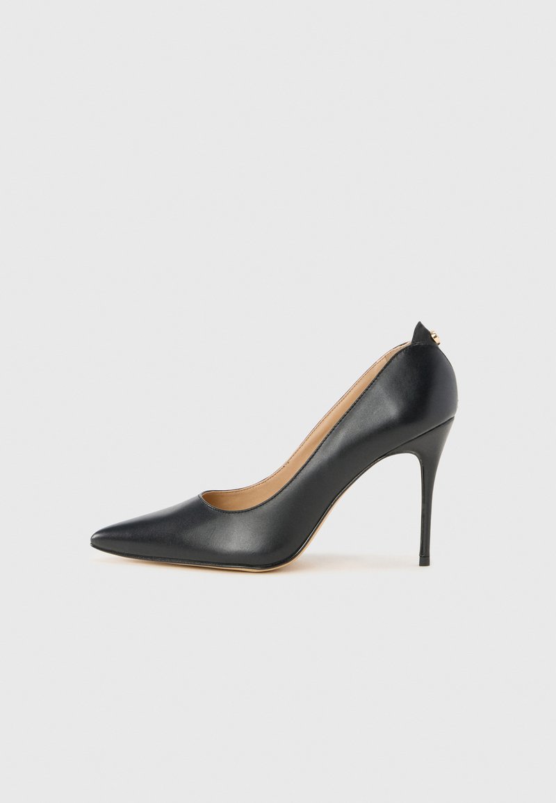 Schwarze Leder-Pumps mit hohen Absätzen, spitzem Zeh, schlankem Design und einem subtilen Cut-Out-Akzent hinten. Erhöhter Stiletto-Absatz.