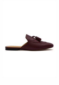 Scarpa in pelle bordeaux senza lacci con punta affusolata, accentata da un pon-pon decorativo e dettagli cuciti sulla parte superiore, caratterizzata da una suola piatta.