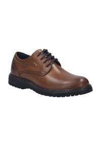 Zapato de cuero marrón con cordones, punta redondeada, detalles de costura y suela de goma negra con patrones de tracción texturizados.