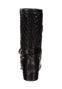 Bota de cuero negro hasta la rodilla con textura acolchada, acento de hebilla y cremallera trasera. Acabado liso y punta redondeada. Tacón bajo apilado.