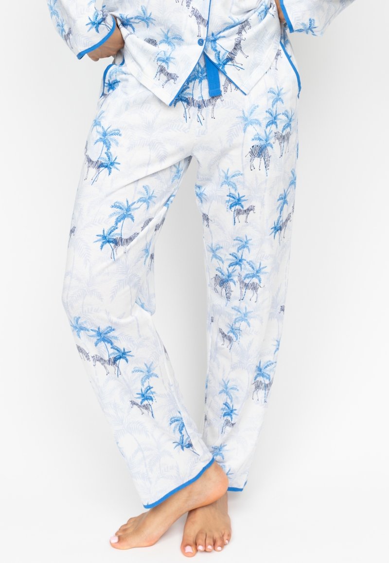 Witte pyjama set met een blauw zebrapatroon en palmbomen, met blauwe bies op de broek en het shirt, met een gladde stofstructuur en een relaxte pasvorm.