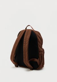 Καφέ σακίδιο από κορδόνι με μαξιλαρωτή πίσω επιφάνεια από μαύρο δίχτυ, ρυθμιζόμενους ιμάντες ώμου και πλαϊνή τσέπη σε λευκό φόντο.