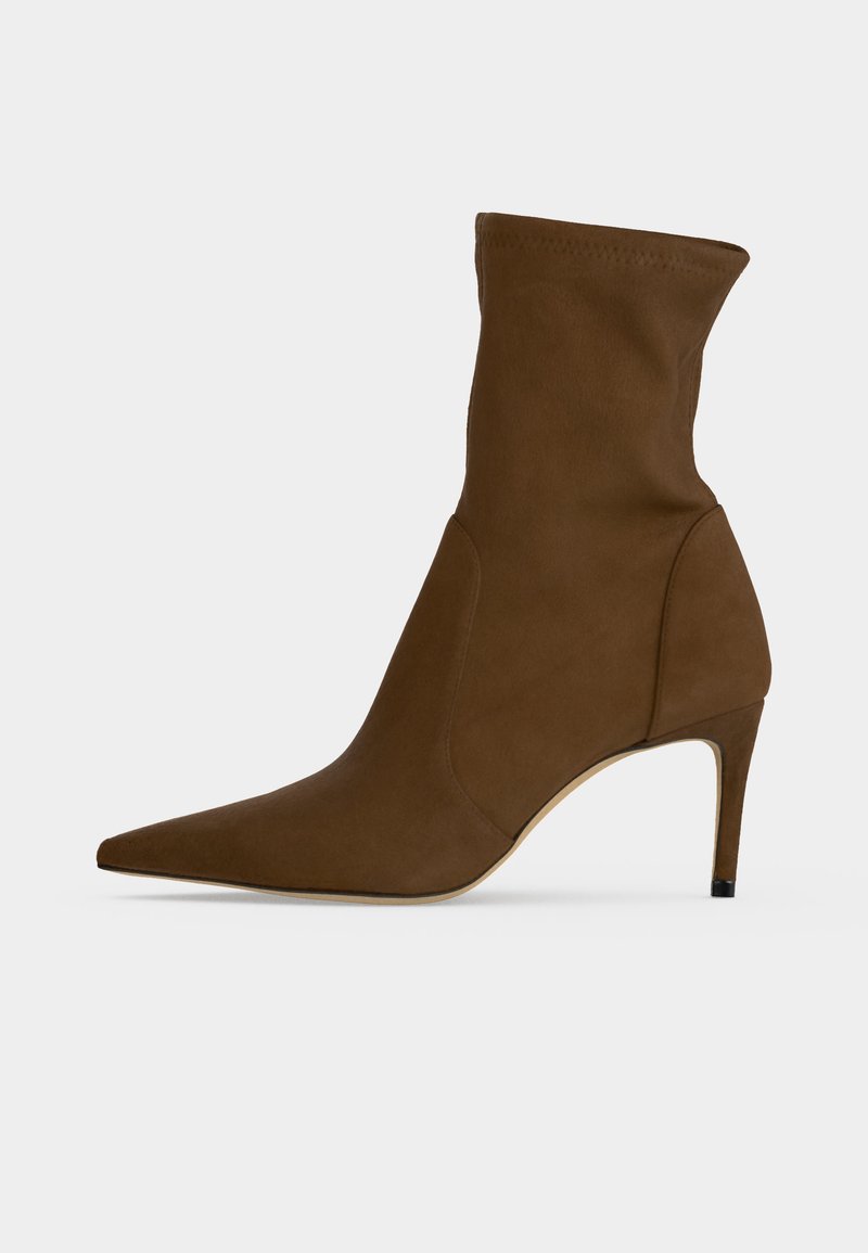 Brown pointed-toe ankle boot with a slim mid-high heel and a smooth fabric upper.