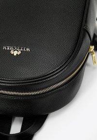 Černý kožený batoh s texturovaným povrchem, se zlatým zipem a logem. Kulatý tvar s nastavitelnými popruhy.