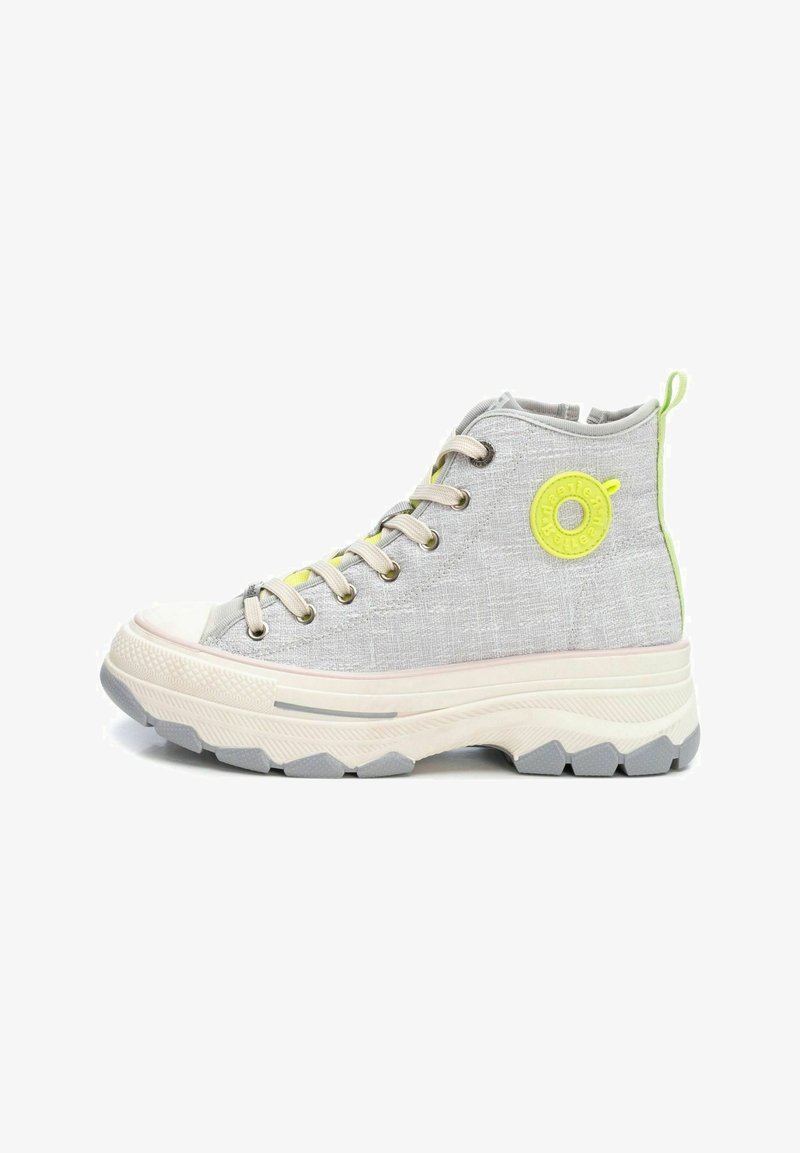 Zapatilla alta en tela gris claro con un patrón texturizado. Presenta detalles en verde lima, cordones beige y una suela gruesa blanca con una banda de rodadura gris.