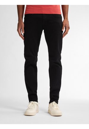 Zwarte katoenen jeans met een slim fit, voorzien van voorzakken en een strak ontwerp, gecombineerd met lichtgekleurde sneakers.