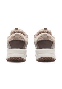 Brown sneakers with thick white soles and beige shearling lining, viewed from the back on a white background.