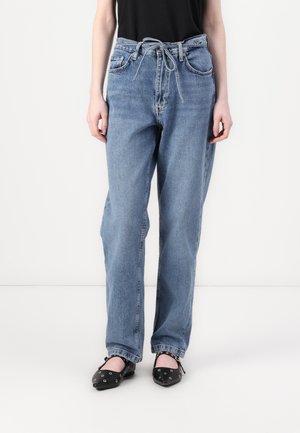 Lichtblauwe denim jeans met een relaxte pasvorm, voorzien van een knoopceintuur, vijf zakken en een gestructureerde afwerking, gecombineerd met zwarte platte schoenen.