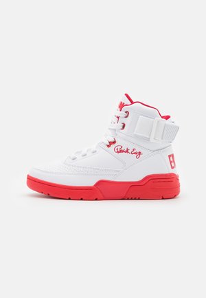 Witte hoge sneaker met rode zool, rode voering, veters aan de voorkant, enkelriem en "Patrick Ewing" handtekening aan de zijkant.