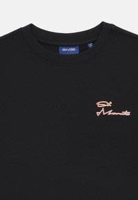 T-shirt en coton noir avec col rond et logo brodé de St. Moritz en orange. Texture lisse, design décontracté, disponible en plusieurs tailles.