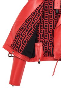 Rode leren jas met een gepatternde zwarte voering met abstracte vormen, ritszakken en slanke aangesloten mouwen.