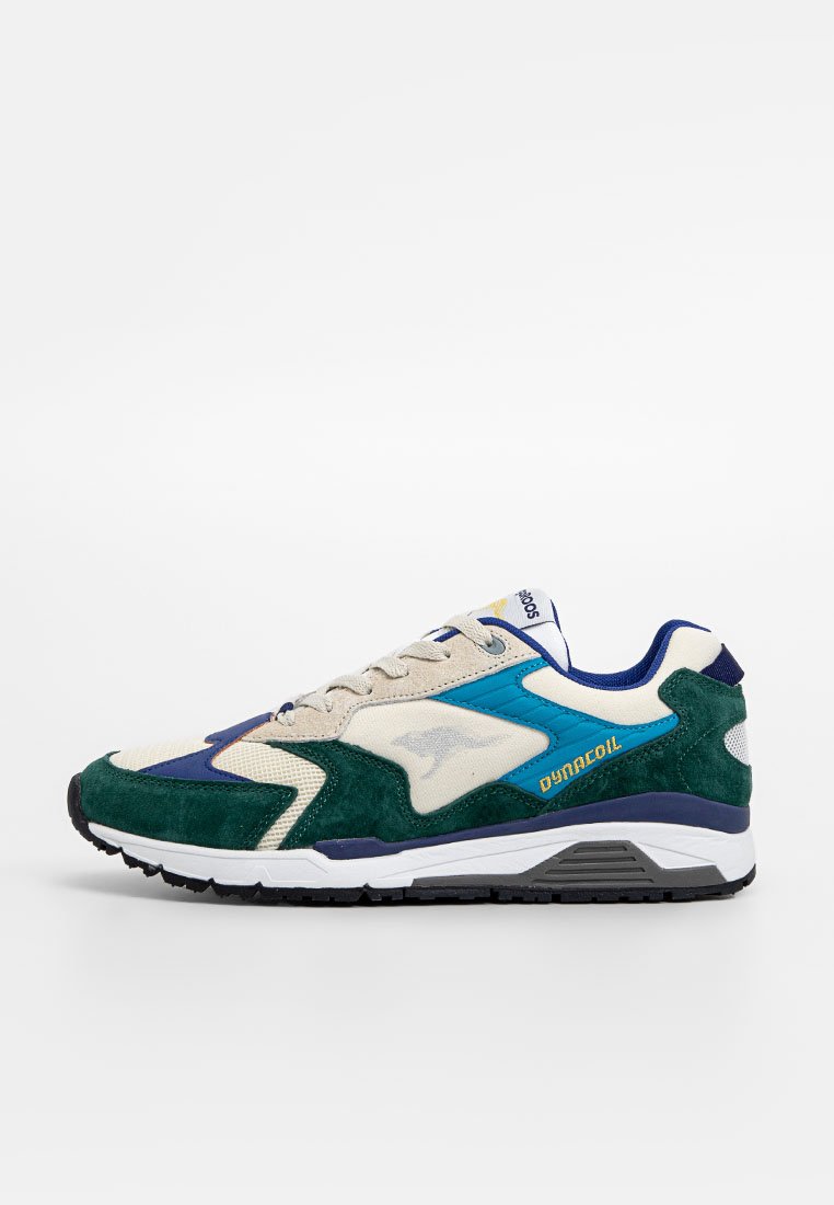 Sneaker met een mix van crème mesh en donkergroene suede met blauwe en teal accenten; gestructureerde zool; "DYNACOIL" branding.