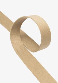 Beżowa wstążka materiałowa, płaska o gładkiej fakturze, zwinięta w pętlę; posiada czyste krawędzie i tkany wzór wzdłuż długości.