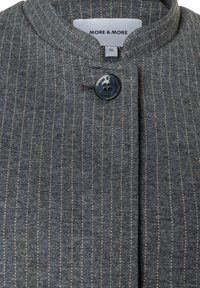 Grau gestreifte Jacke aus strukturiertem Stoff, mit rundem Kragen und schwarzer Knopfleiste. Das Etikett trägt die Aufschrift "MORE & MORE", Größe 36.