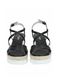 Sandalias de cuero negro con tiras entrelazadas, suela de yute estilo espadrille, media suela blanca y acentos de hardware plateado.