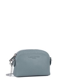 Pochette in pelle azzurro chiaro con hardware argento e una tracolla a catena. Forma arrotondata, chiusura a zip e marchio in rilievo sulla parte frontale.