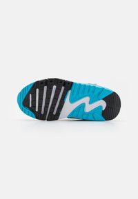 Suola di scarpa atletica nera e acquamarina con gomma testurizzata, battistrada pronunciato e motivo a onda, con un accento bianco al centro.