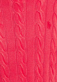 Maglione a maglia di un vivace colore rosa, caratterizzato da un motivo a trecce con punti torcivati in rilievo. Texture liscia con un leggero lucido.