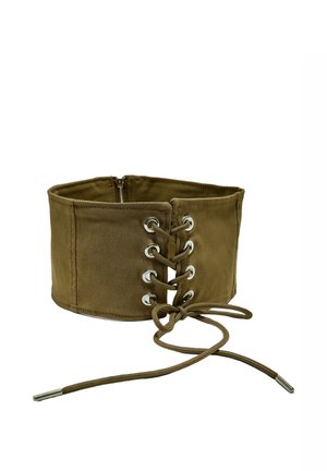 Ampia cintura in tessuto verde oliva con lacci frontali e occhielli argentati, chiusura con zip sul retro e lunghi lacci legati davanti.