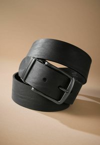 Ceinture en cuir noir avec une finition texturée, dotée d'une boucle rectangulaire en argent mat et de plusieurs trous d'ajustement, présentée en position bouclée.