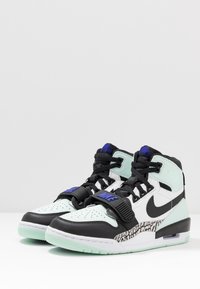 Vysoké tenisky v mátově zelené a černé barevné kombinaci, z koženého a gumového materiálu, s texturovanými prvky a viditelnou jednotkou Air v podrážce.