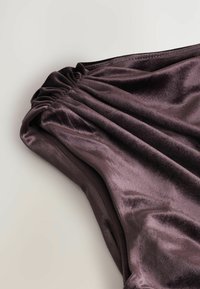 Dunkelviolettes Satin-Kleid mit gerafftem Stoff an der Schulter. Glatte Oberfläche und eleganter Fall, der die reiche Farbe und den glänzenden Schimmer zur Geltung bringt.
