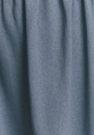 Mäkká tkanina v tlmenej modrej farbe s textúrovaným vzhľadom. Materiál pôsobí ľahko, jemne sa zahaľuje s nenápadnými záhybmi.