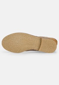 Sandale en cuir marron avec une semelle en caoutchouc texturée. La semelle est de couleur brun clair, arrondie et légèrement surélevée au niveau du talon.
