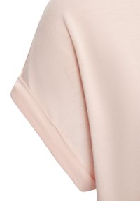 Hele roosa puuvillane T-särgi varrukas, millel on sile tekstuur, volditud mansett ja õrn sära kangapinnal.