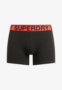 Schwarz und olivgrün gestreifte Boxershorts mit einem breiten roten Bund, auf dem "SUPERDRY" in Schwarz gedruckt ist. Hergestellt aus weichem Material.