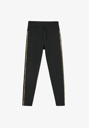 Czarne legginsy z wysokim stanem, sznurkiem do regulacji i złotym logo wzdłuż bocznych szwów. Gładka, elastyczna tkanina.