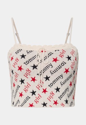 Knitted crop top featuring a cream base with red and black stars and text patterns. Thin adjustable straps and a lace-up front detail.