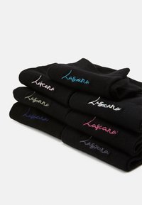 Black cotton socks stacked with visible embroidered branding in various colors: pink, blue, purple, and white. Smooth texture, rolled cuffs.
