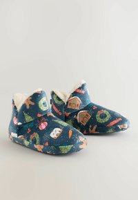 Blue fabric slippers with festive patterns, featuring soft fur lining, rounded toe, and ankle height. Design includes Christmas motifs.