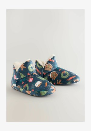 Pantofole di stoffa blu con motivi festivi, dotate di morbido rivestimento in pelliccia, punta arrotondata e altezza alla caviglia. Il design include motivi natalizi.