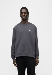 Γκρι φούτερ με στρογγυλή λαιμόκοψη και μακριά μανίκια. Διαθέτει μικρό λευκό λογότυπο στο στήθος. Μαλακό ύφασμα και άνετη εφαρμογή. Συνδυάζεται με σκούρα παντελόνια.