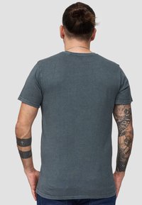 Mørkegrå bomulds t-shirt med korte ærmer og rund halsudskæring, der har en blød tekstur og et minimalistisk design.