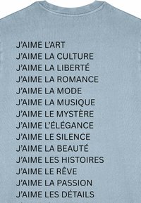 Šviesiai mėlynas marškinėlis su juodu tekstu, kuriame užrašyti žodžiai "J'AIME"; minkštas medvilnės audinys, apvalus iškirpimas, tekstas tolygiai išdėstytas, be grafikų.