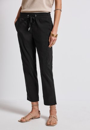 Pantalons courts noirs, légers, avec taille élastique et cordon de serrage. Dotés de poches latérales et d'une coupe décontractée. Texture douce et design casual.