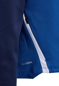 Tessuto atletico blu e navy con motivi testurizzati, caratterizzato da una zip bianca e la scritta "BECOOL" stampata in bianco vicino alla cucitura.