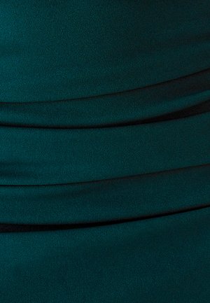 Tela verde azulado oscuro con pliegues suaves y en capas que crean un patrón texturizado y ligeramente curvado.