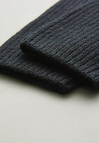 Must mustriba kootud kangas, pehme tekstuur, kahest kuhjatavast osast koosnev, millel on ühtlased servad. Minimalistlik disain ilma nähtava riistvarata.