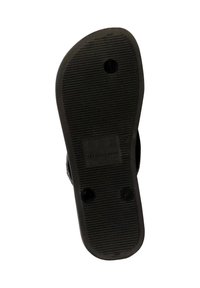 Sole di scarpa in gomma nera con texture a righe, due fori circolari e dettagli del marchio in rilievo sulla superficie.