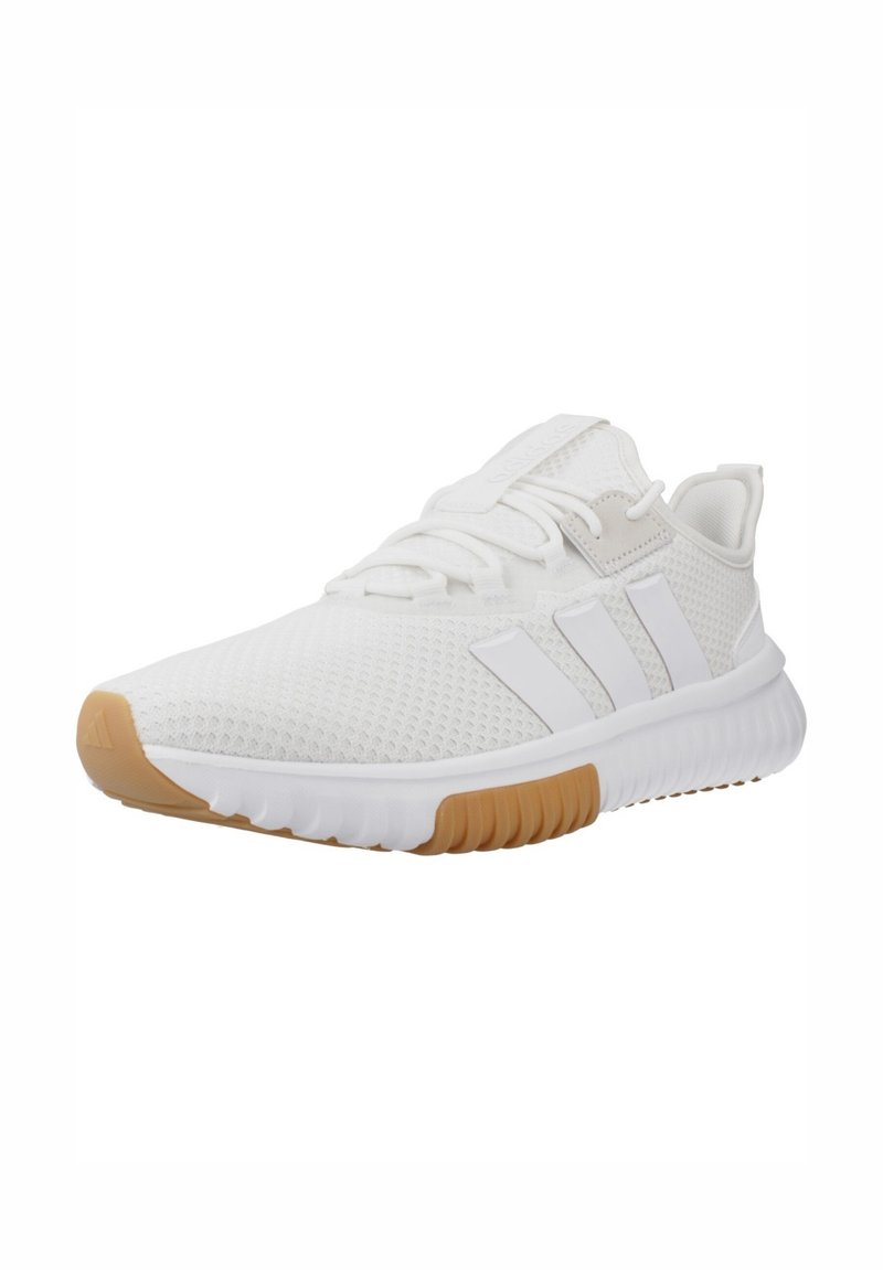 White textured athletic sneaker with beige rubber sole, three white side stripes, lace-up design, and branded tongue tab.