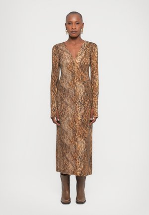 Long-sleeve, V-neck dress in a brown animal print pattern, made from a smooth textile; fitted silhouette with side slits, paired with brown boots.