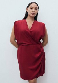 Red wrap dress with short sleeves, soft fabric, V-neckline, draped design, and a fitted waist creating a smooth silhouette.