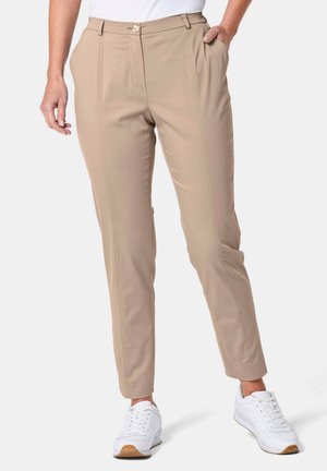 Beige op maat gemaakte broeken met een gladde textuur, rechte snit, voorplooien en een enkele knoopsluiting. Gecombineerd met witte sneakers.