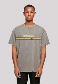 Light gray oversized t-shirt made of cotton, featuring a colorful "Pink Floyd" graphic with a triangle and horizontal stripes.